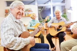 group of elderly people in hospice playing guitar