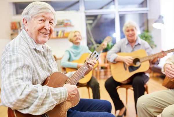 group of elderly people in hospice playing guitar