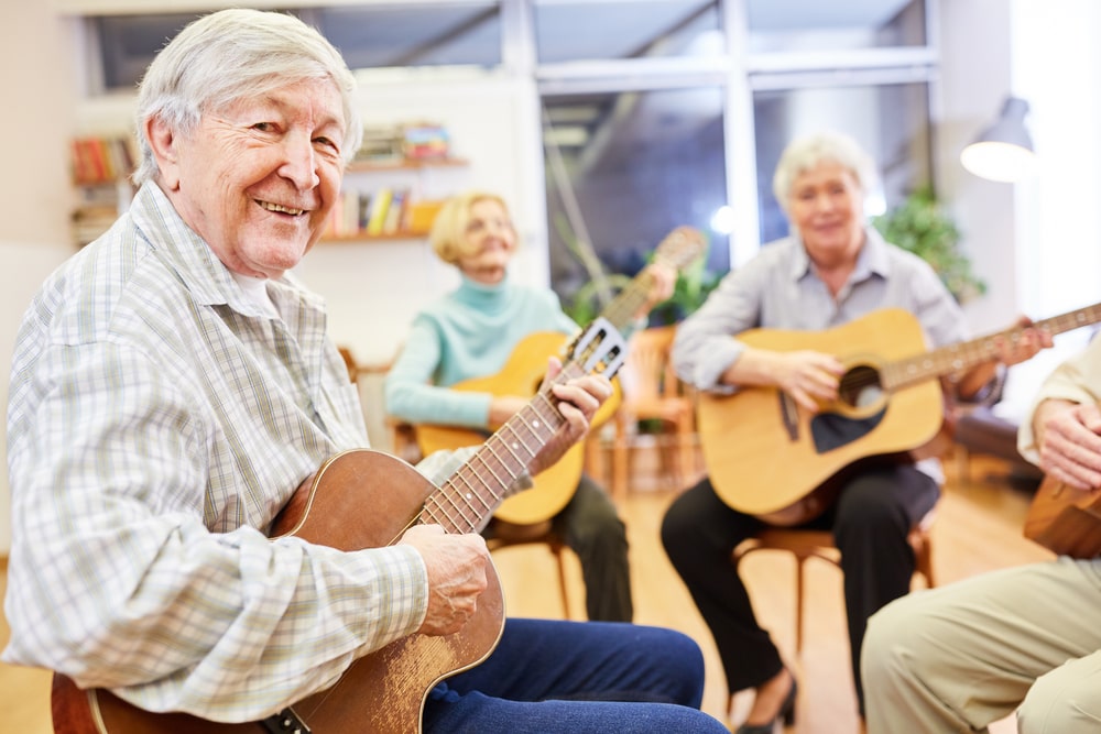 group of elderly people in hospice playing guitar