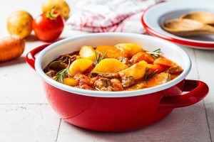 stew with potatoes in a red pot