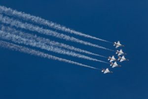 Six Air Force jets in the sky with white jet stream following them