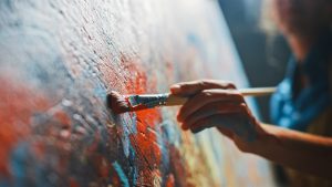 close up of a person painting on a canvas