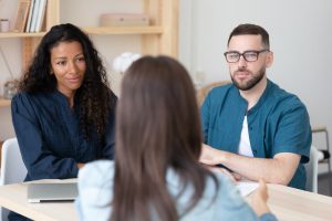 Man and woman sitting down with a professional to discuss