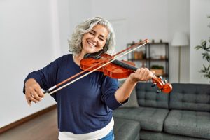 Mature woman in dark blue shirt playing a violin