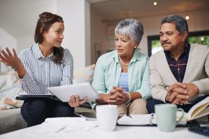 Husband and wife sitting on couch at home as they speak with a funeral professional