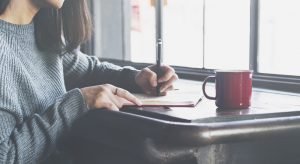 Woman writing a letter to her mom in a journal