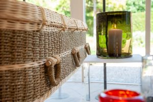 Wicker casket with memorial candle nearby