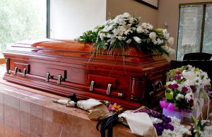 Wooden casket surrounded by flowers