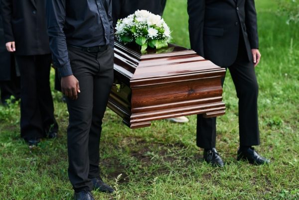 Pallbearers carrying casket to burial space