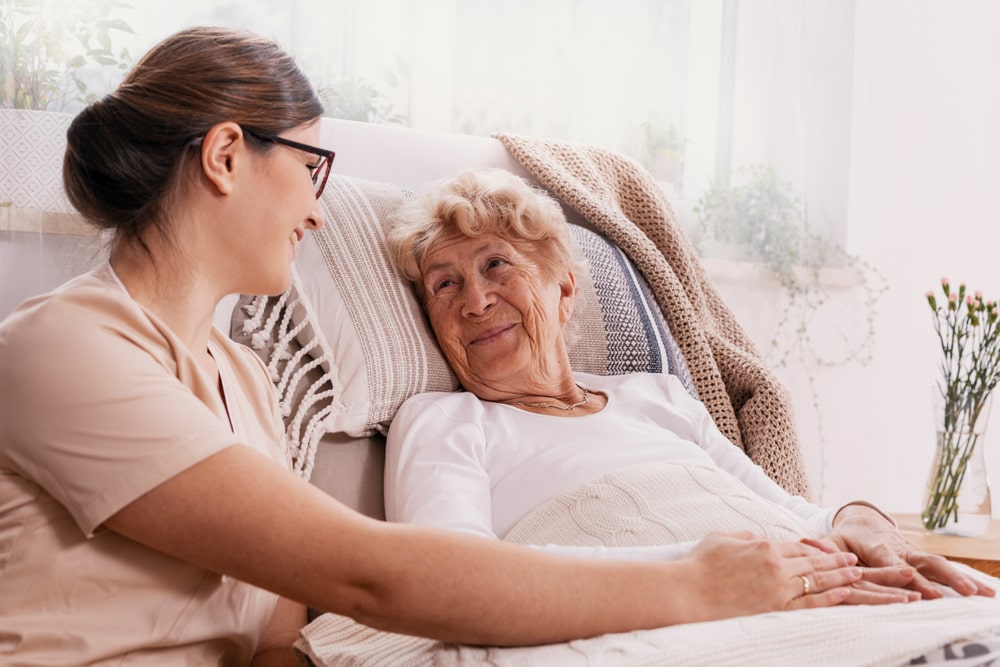 woman volunteer sitting next to an elderly woman on a couch