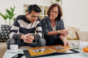 Mother and son looking at photo album, remembering a lost loved one