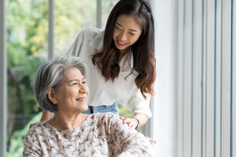 young woman pushing an elderly woman in a wheelchair