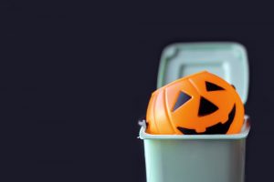 Halloween pumpkin candy pail in the trash can