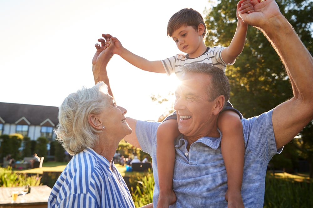 older couple playing with their young grandson outside