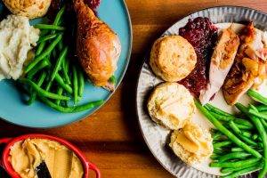Simple Thanksgiving meal of biscuits, green beans, and turkey with cranberry sauce
