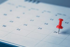 Calendar with red thumbtack on a specific date