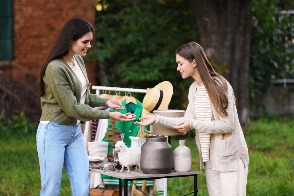 Two women at an estate sale, one buying an item