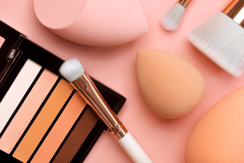 makeup and eyeshadow palette with brushes and beauty blenders
