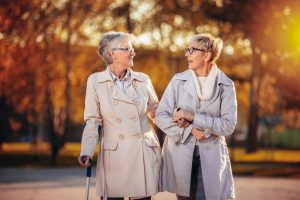 Two mature ladies walking outside and talking in the fall