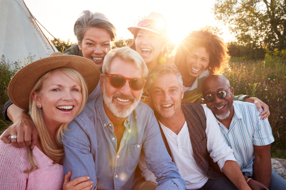 group of people of mixed ages, races, and gender, smiling with a positive mindset