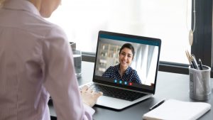 man attending online therapy on his laptop