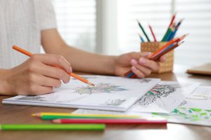 Person sitting at table and actively coloring