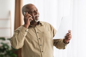 Mature African American man makes phone call from his home; prepping for preplanning