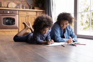 Mother and young daughter coloring together and relaxing