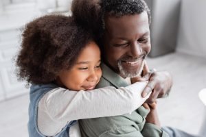 girl hugging an older man in a green shirt