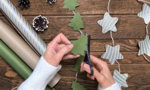 Person making a garland with Christmas trees and stars