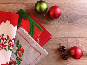 Four Christmas table runners sitting on table with ornaments