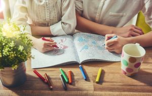 Man and woman sitting at a table together and coloring