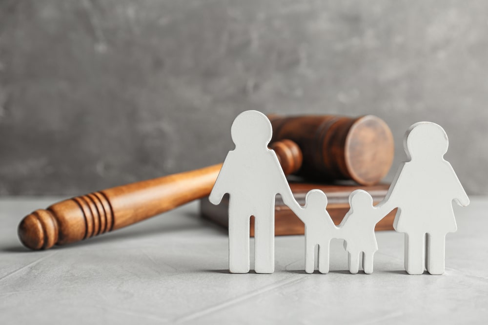 paper cutout of a family in front of a gavel 