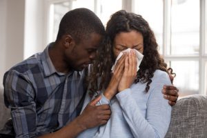 man hugging and comforting a woman crying