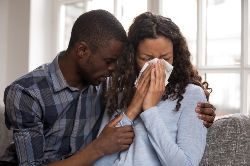 man hugging and comforting a woman crying