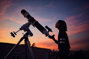 Young girl looking up at the night sky, looking for a registered star
