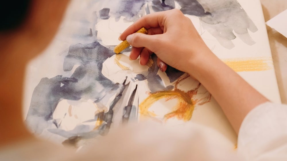 close up of person drawing with pastels