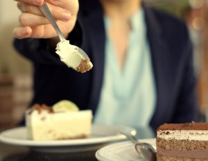 Woman holding out a forkful of key lime pie at a gathering