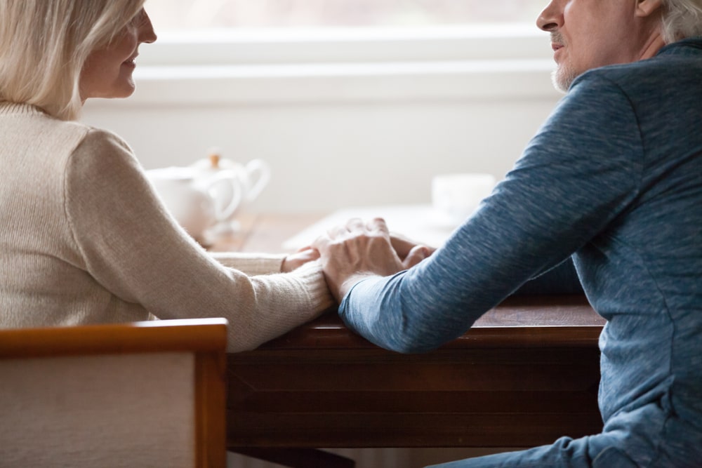 husband and wife holding hands and talking to each other