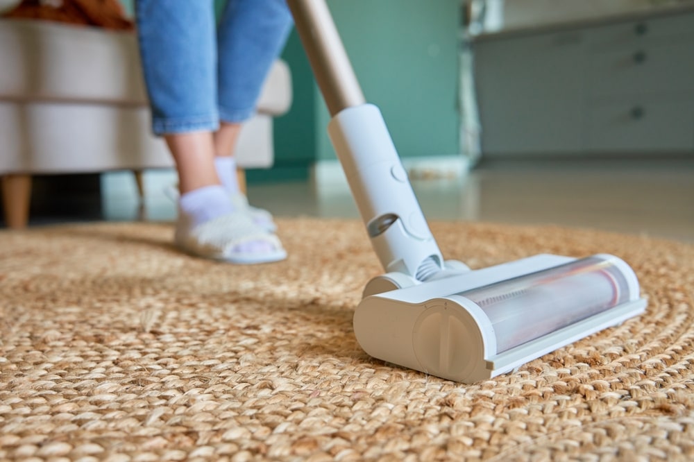 person vacuuming a rug