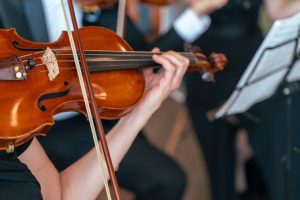 Woman playing a violin with an orchestra
