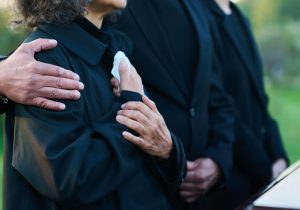 People at graveside service in modest clothing
