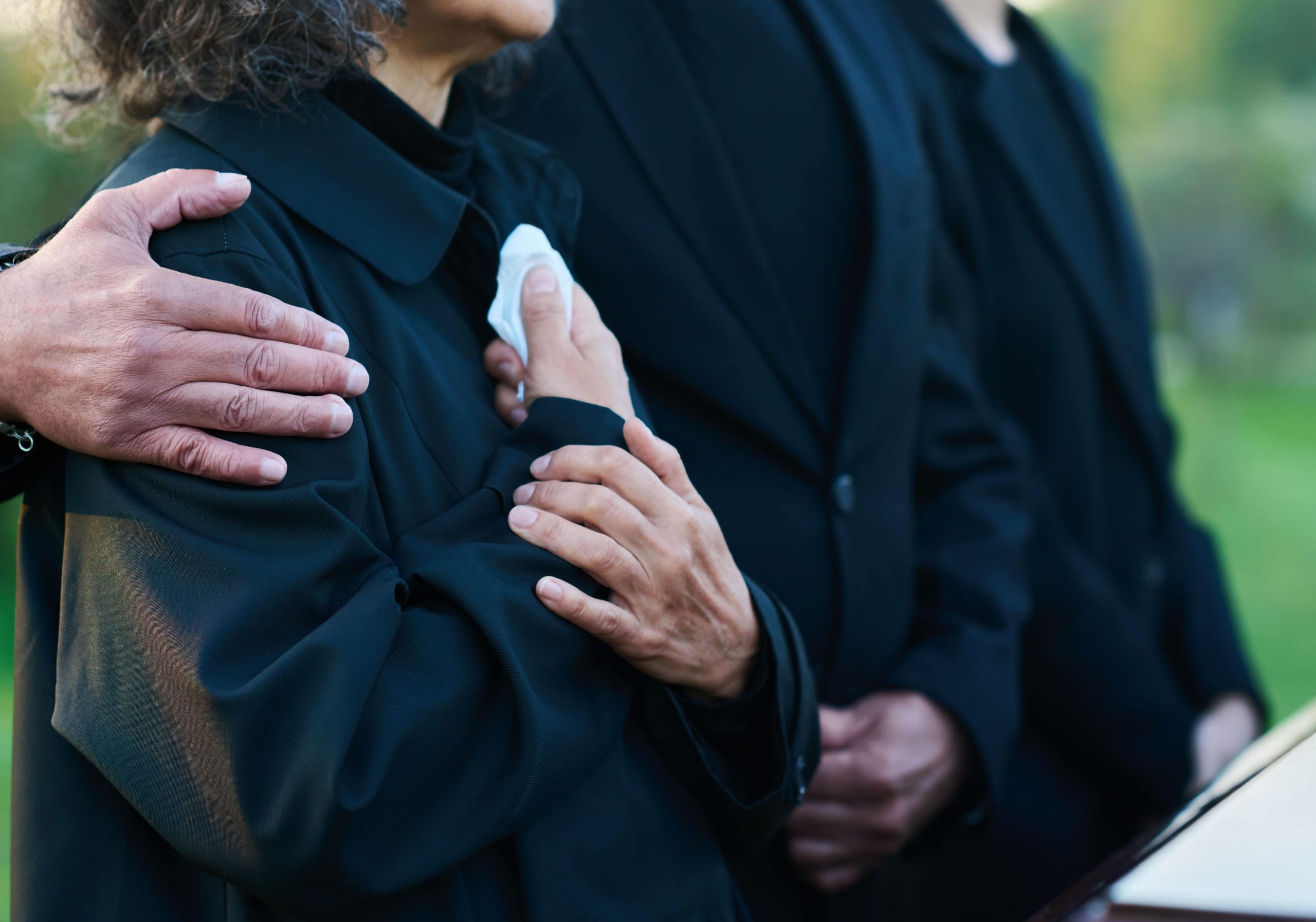 People at graveside service in modest clothing