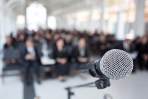 microphone in front of a crowd at a funeral