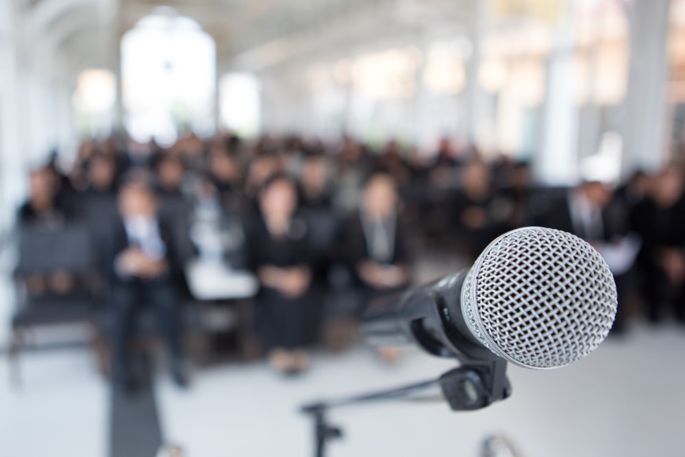 microphone in front of a crowd at a funeral