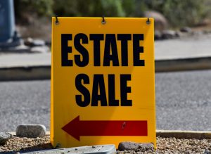 Yellow estate sale sign with a red arrow pointing to the left