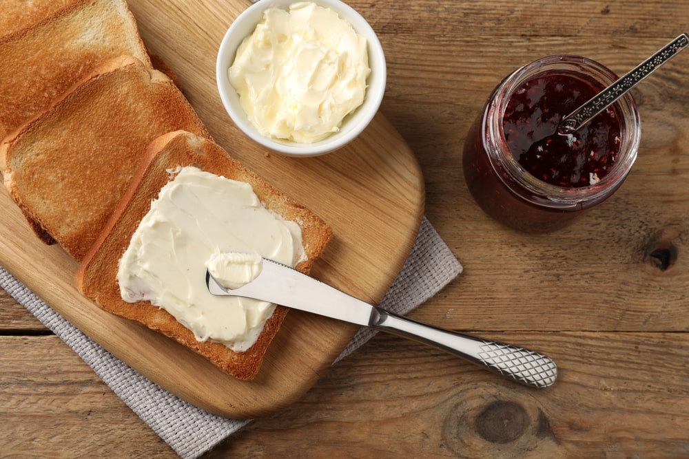Plain toast with butter on top and a butter knife resting on it