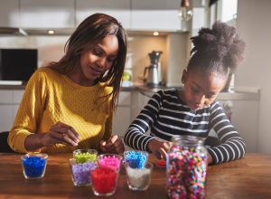 Mother and daughter creating jewelry with beads