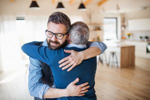 Father and adult son hugging each other