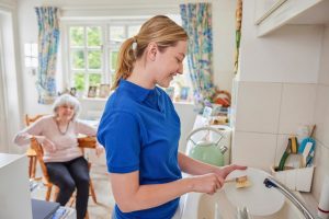 Hospice nurse washing dishes in a patient's home